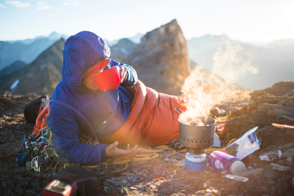 Drinking First Ascent Instant Coffee in a sleeping bag atop a mountain.